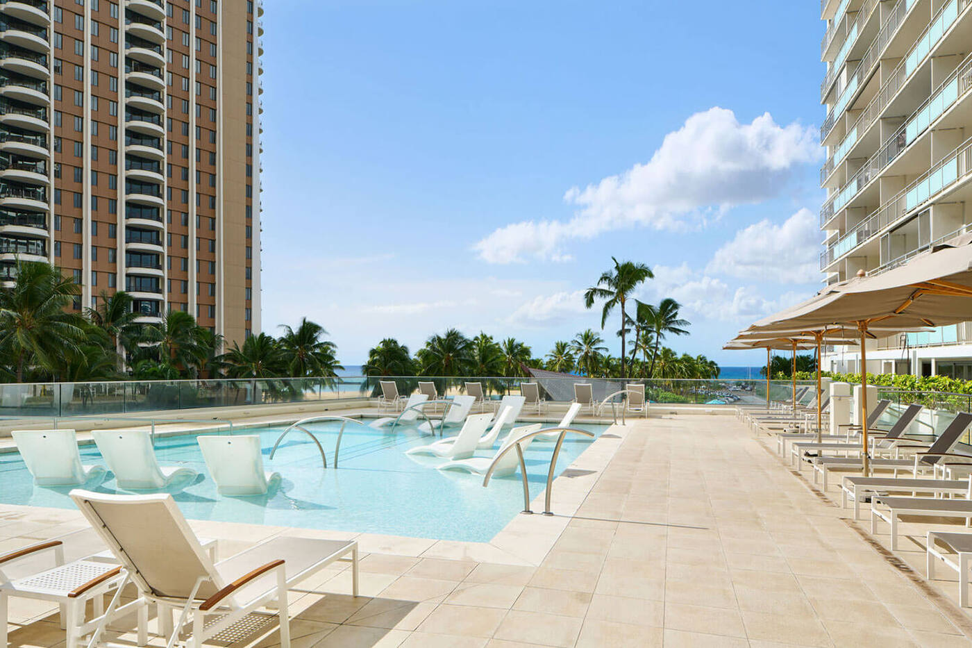 Outdoor pool and sun deck with loungers.