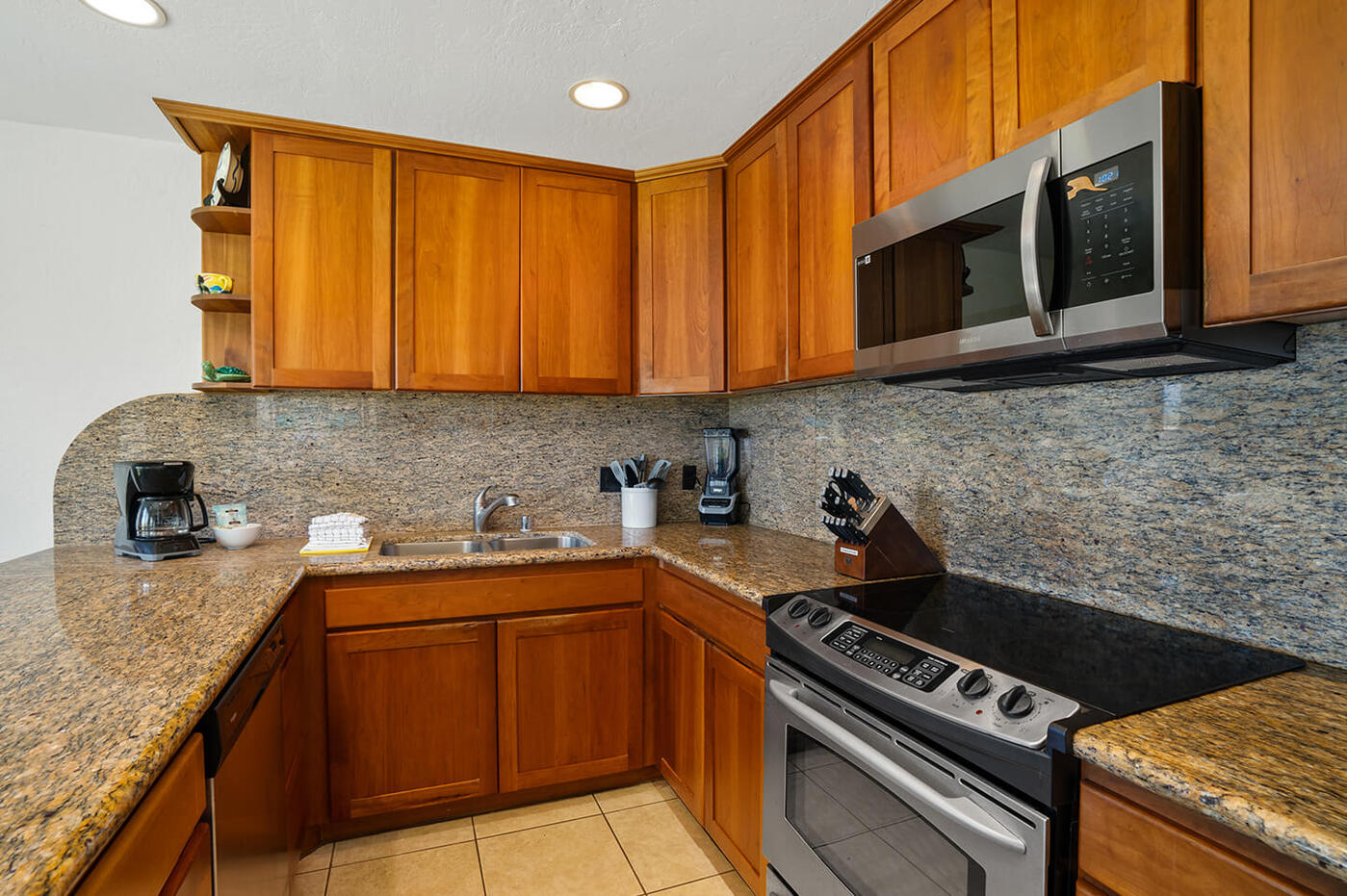 Kitchen counter top, stove, refrigerator, sink, microwave.