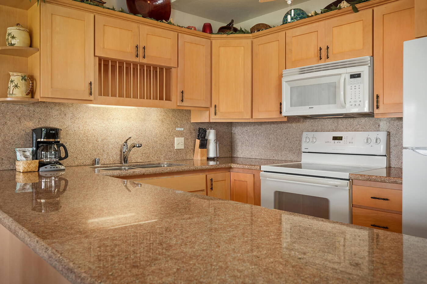 Kitchen counter top, stove, refrigerator, sink, microwave.